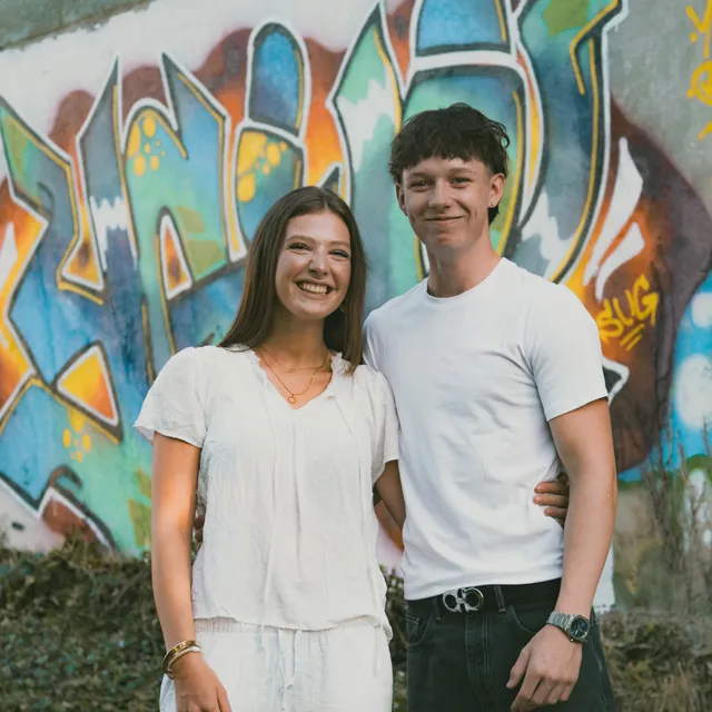 Mutter und Sohn vor einer bunten Graffitiwand